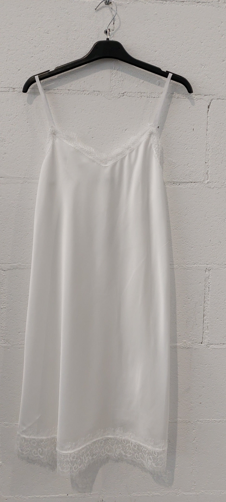 Sottoveste realizzata in raso con inserti di pizzo sullo scollo a V e sul fondo. Spallina sottile regolabile. Composizione 100%poliestere made in italy