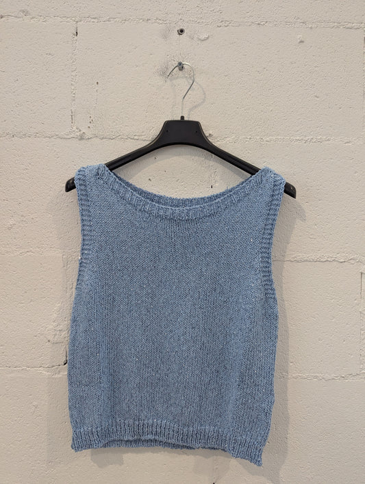 Fresca, essenziale e senza tempo: questa canotta in maglia di colore blu cielo è il capo perfetto per la stagione primaverile ed estiva. Realizzata in filato morbido e leggero, presenta una linea dritta e una scollatura ampia e delicata che valorizza il décolleté senza essere eccessiva.

Il bordo a costine sullo scollo e sull’orlo inferiore aggiunge un tocco di struttura, mantenendo il look casual ma curato. Facile da abbinare a jeans, gonne o pantaloni in lino per uno stile rilassato ma raffinato.