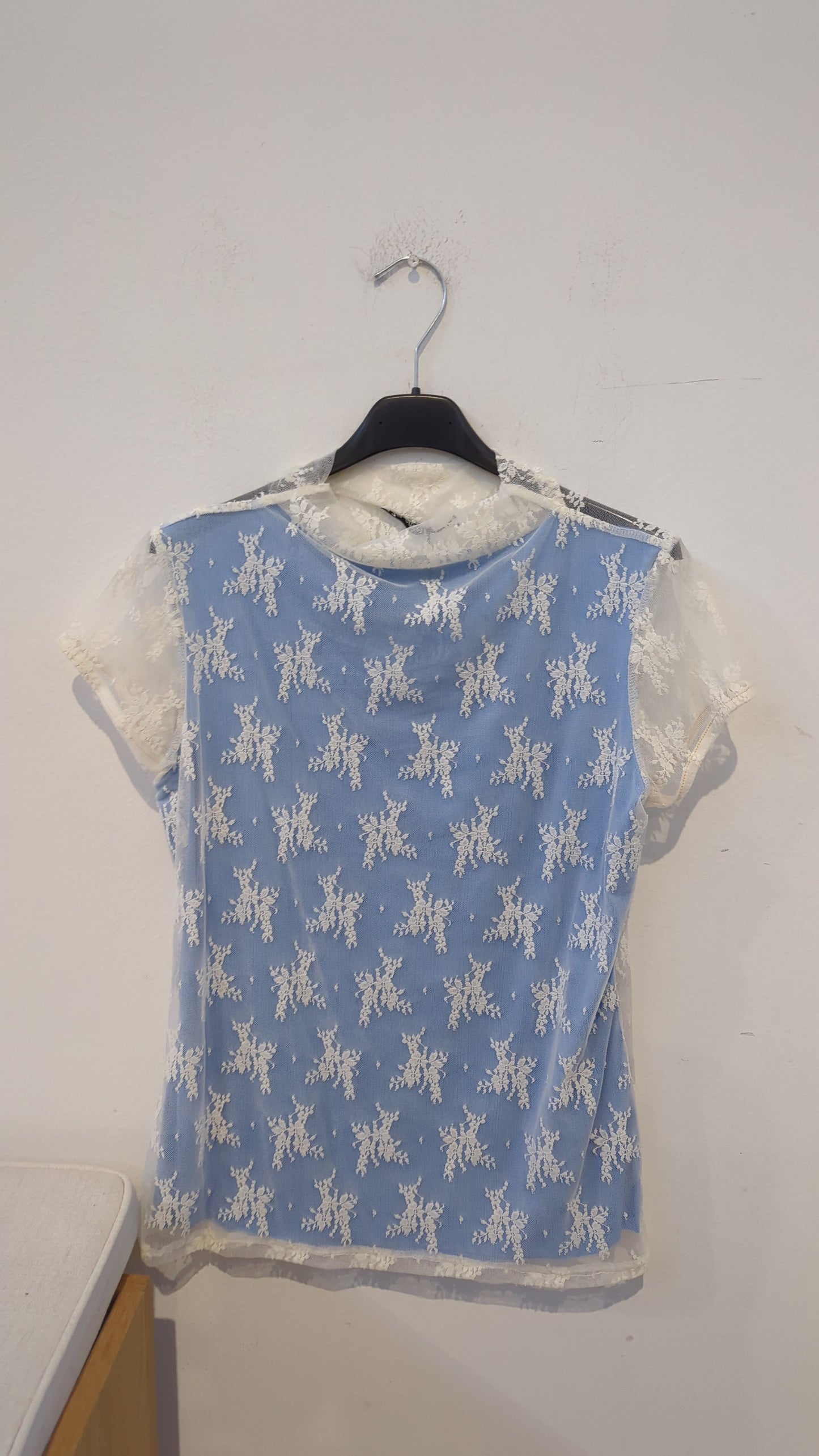 Questa maglia è davvero romantica e delicata: ha una base bianca con maniche in pizzo e un inserto azzurro 